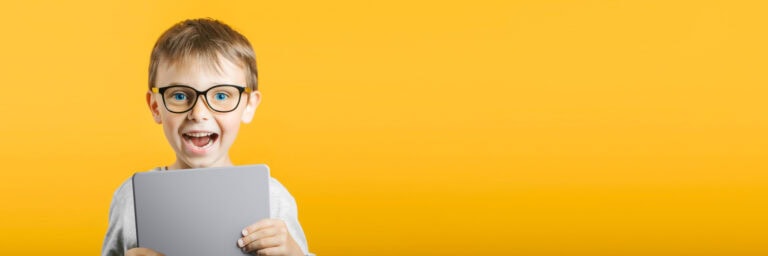 Happy child boy holding a tablet ipade for your information on the blue background