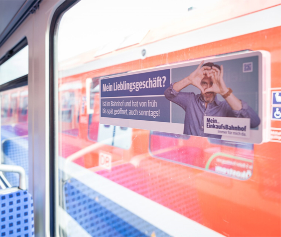 Seitenscheibenplakat mit Werbung am Fenster in einer Straßenbahn