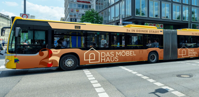 Gelber Bus mit Werbemotiven, fährt in städtischer Umgebung; geschäftige Szenerie.