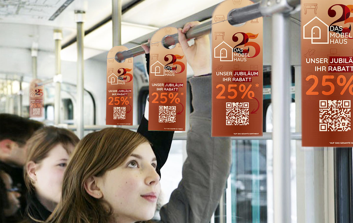 Person im Bus, schaut nach oben, Swing Cards mit Werbung für Möbelhaus auf Haltestangen