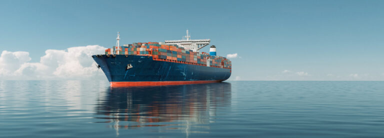 Ein großes Frachtschiff im Ozean voller Container unter blauem Himmel.