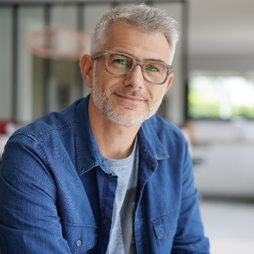 Ein Mann mittleren Alters mit Brille und blauem Hemd